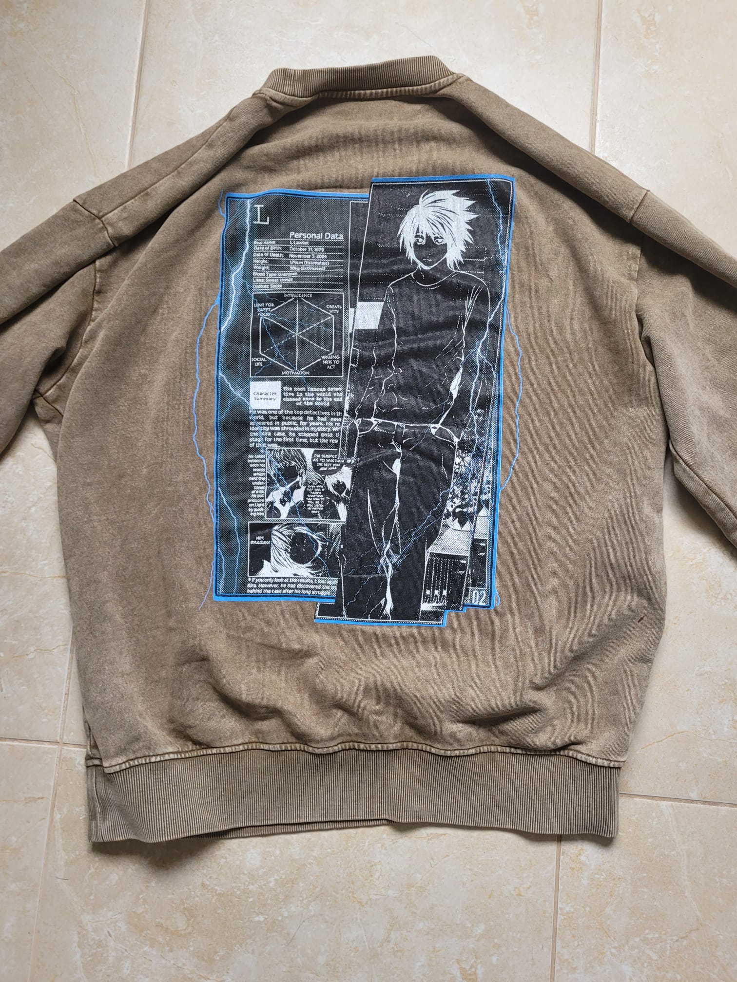 Brown jacket with graphic design on the back on a tiled floor