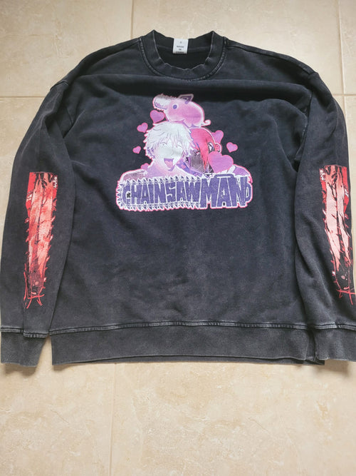 Black sweatshirt with 'Chainsaw Man' graphic design on a beige tiled floor